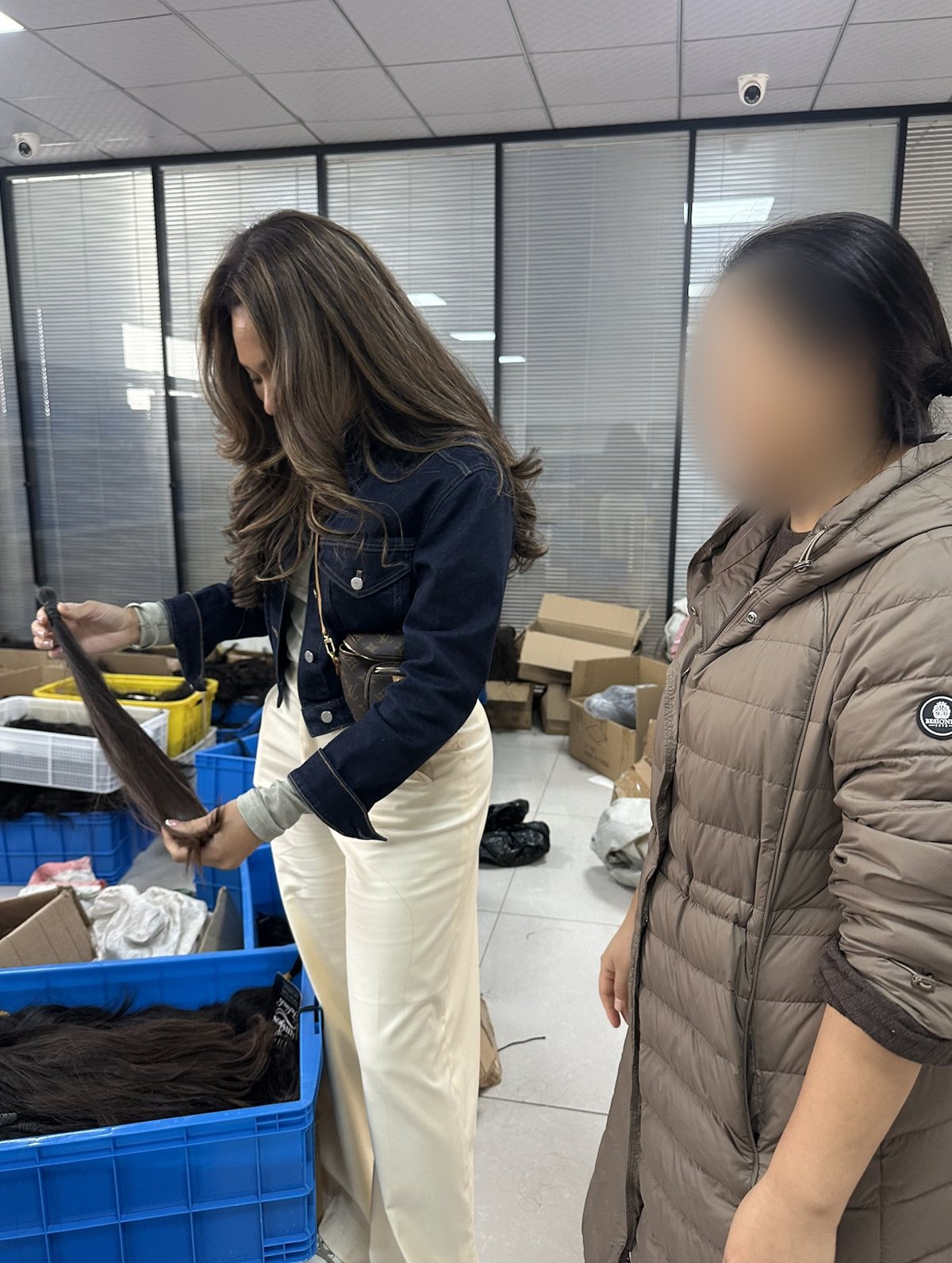 Erin inspecting a hair bundle at a supplier's warehouse